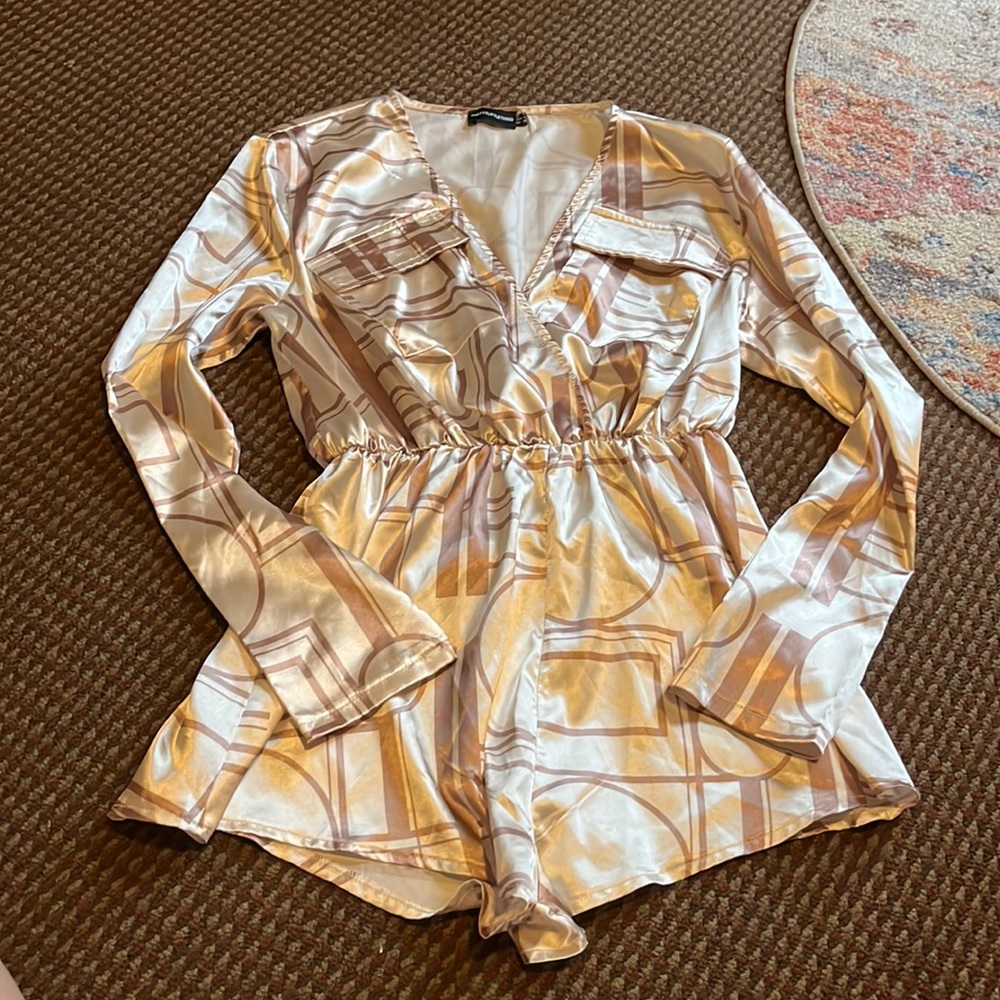 Cream romper with drown pattern.
